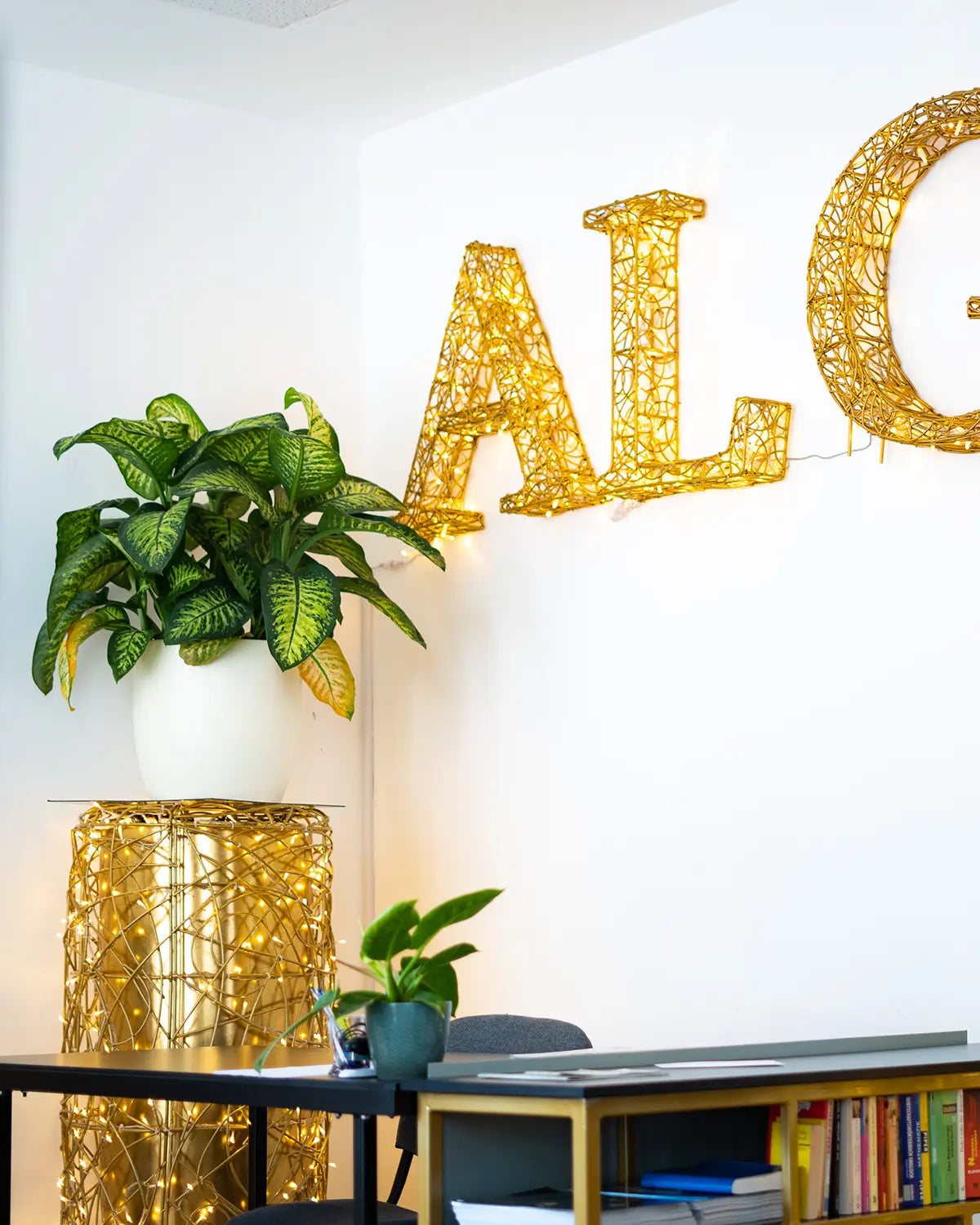 Leuchtende Alganic-Buchstaben als Wandinstallation in einem modernen Büro – kombiniert mit Pflanzengefäß im Alganic Stil