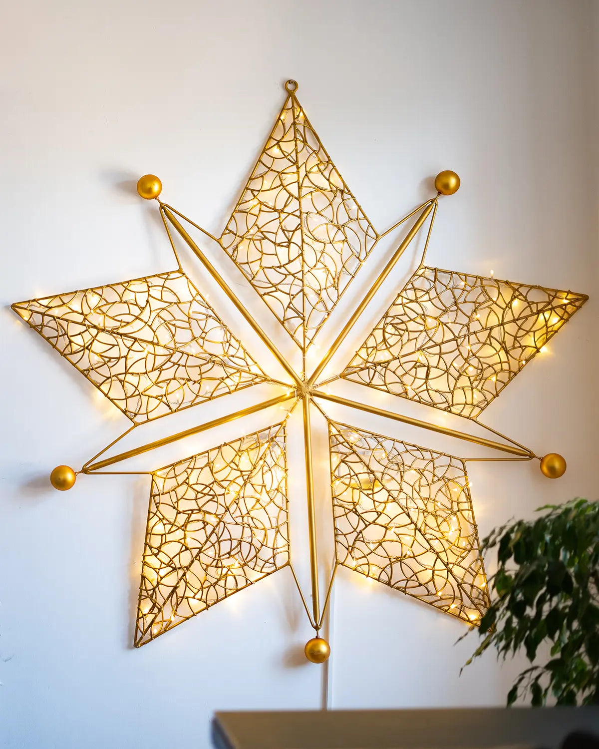 Goldener Alganic-Wandstern mit feinem Lichtgeflecht – skulpturales Leuchtobjekt für Innenräume mit festlicher Wirkung.